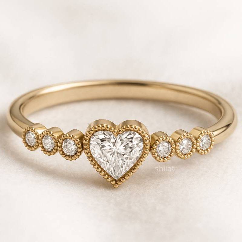 Gold ring with a heart-shaped diamond on a light background