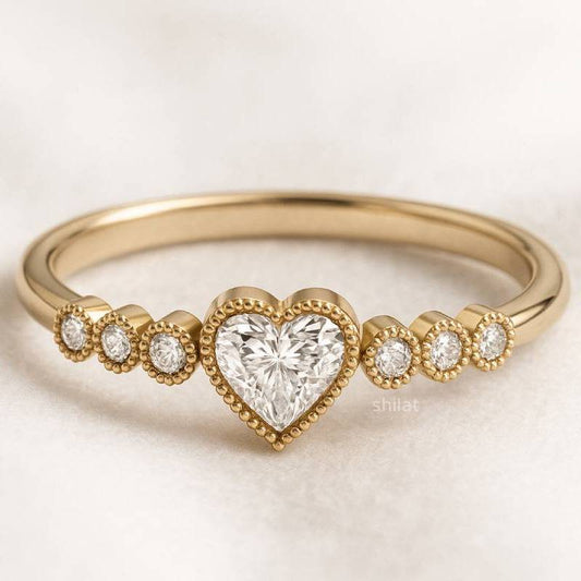 Gold ring with a heart-shaped diamond on a light background