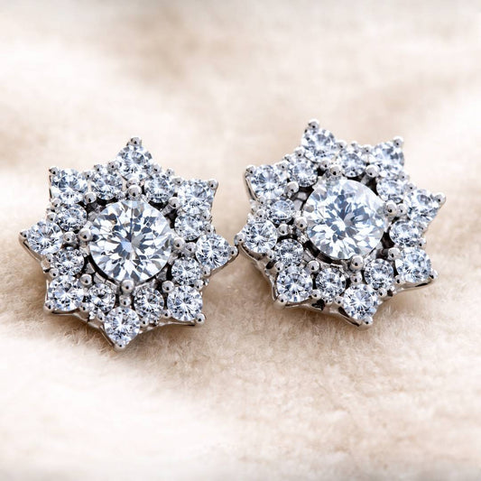 Pair of diamond earrings on a beige background