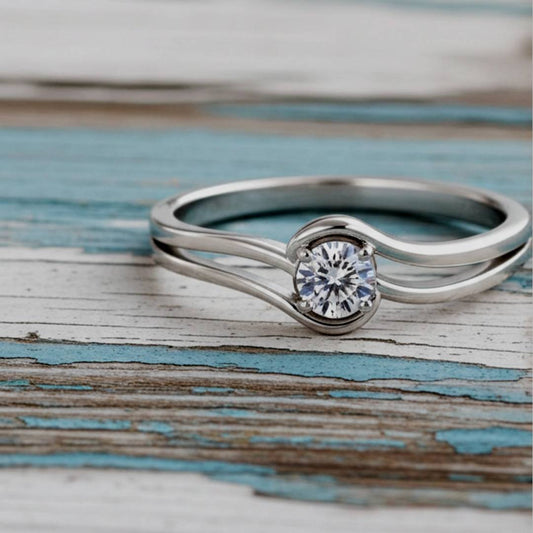 ring with a diamond on a wooden surface