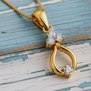 Gold pendant with diamond accents on a wooden surface
