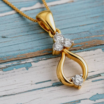 Gold pendant with diamond accents on a wooden surface