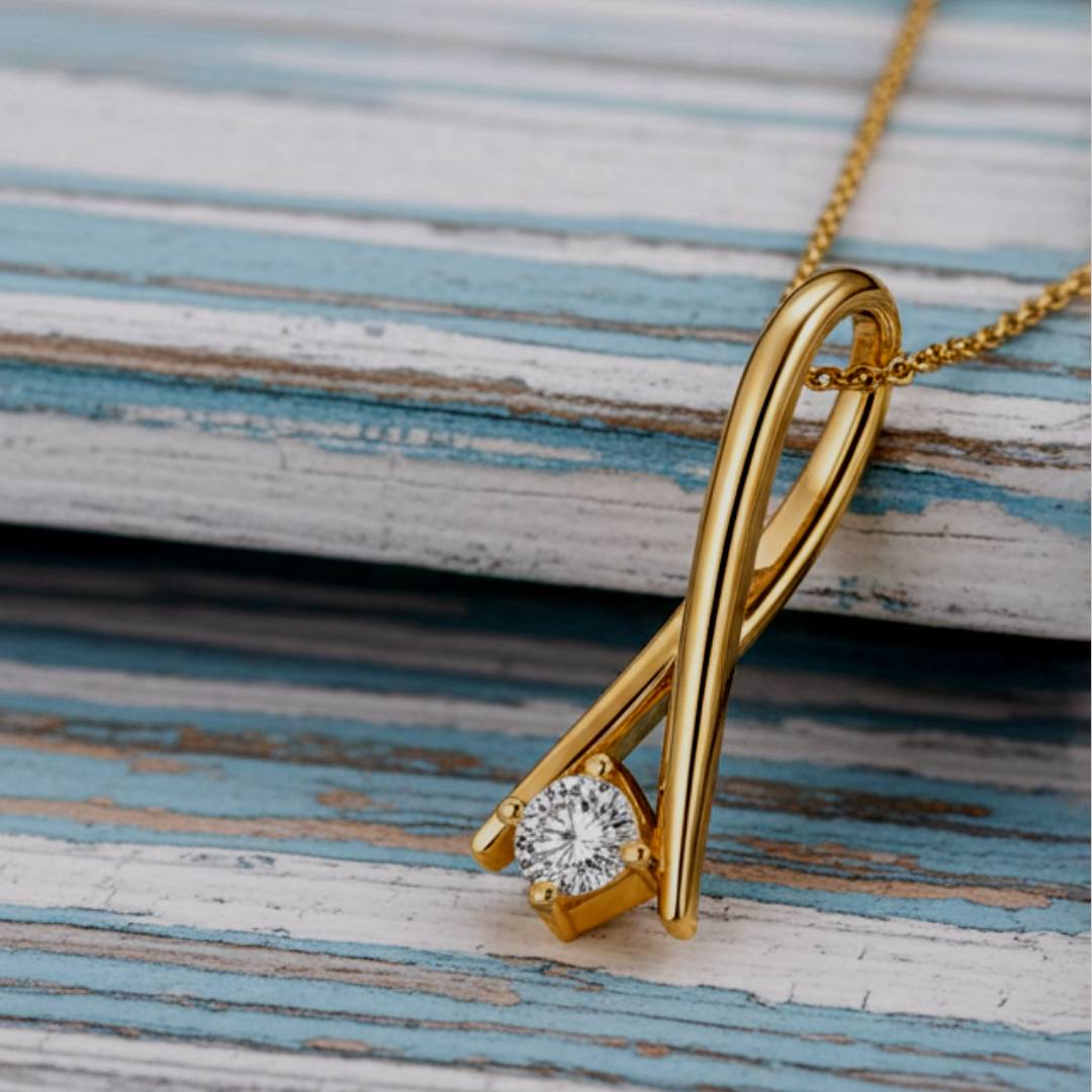 Gold pendant with a diamond on a wooden surface
