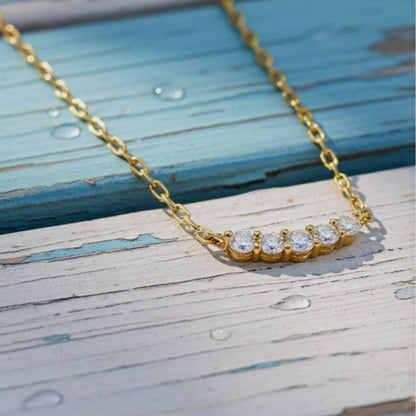 Gold necklace with diamonds on a wooden surface