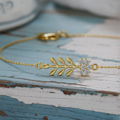 Gold bracelet with floral design on a rustic wooden surface