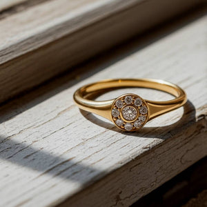 Gold ring with diamond accents on a wooden surface