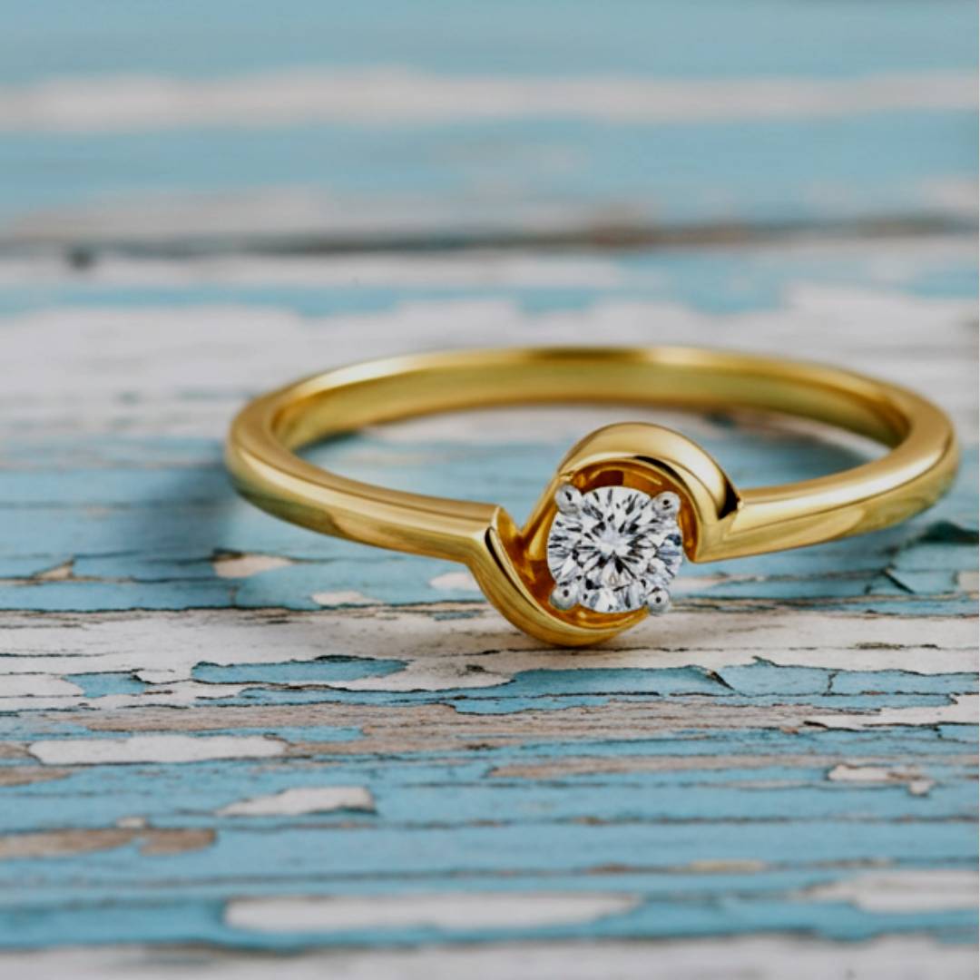 Gold ring with a diamond on a textured blue and gray background