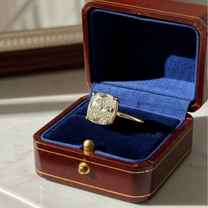 Diamond ring in a brown jewelry box with blue interior