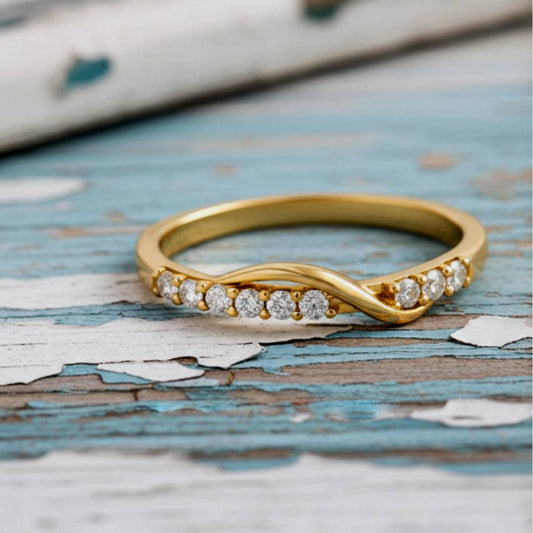 Gold ring with diamonds on a textured wooden surface