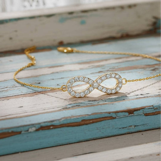 Gold bracelet with an infinity design on a rustic wooden surface