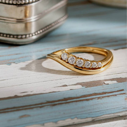 Gold ring with diamonds on a wooden surface