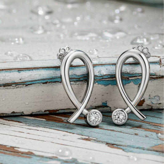  heart-shaped earrings with gemstones on a rustic wooden surface.