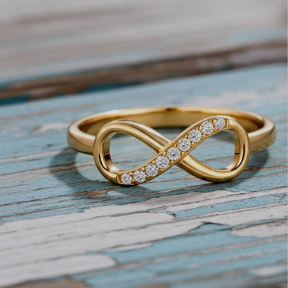 Gold infinity ring with diamonds on a wooden surface