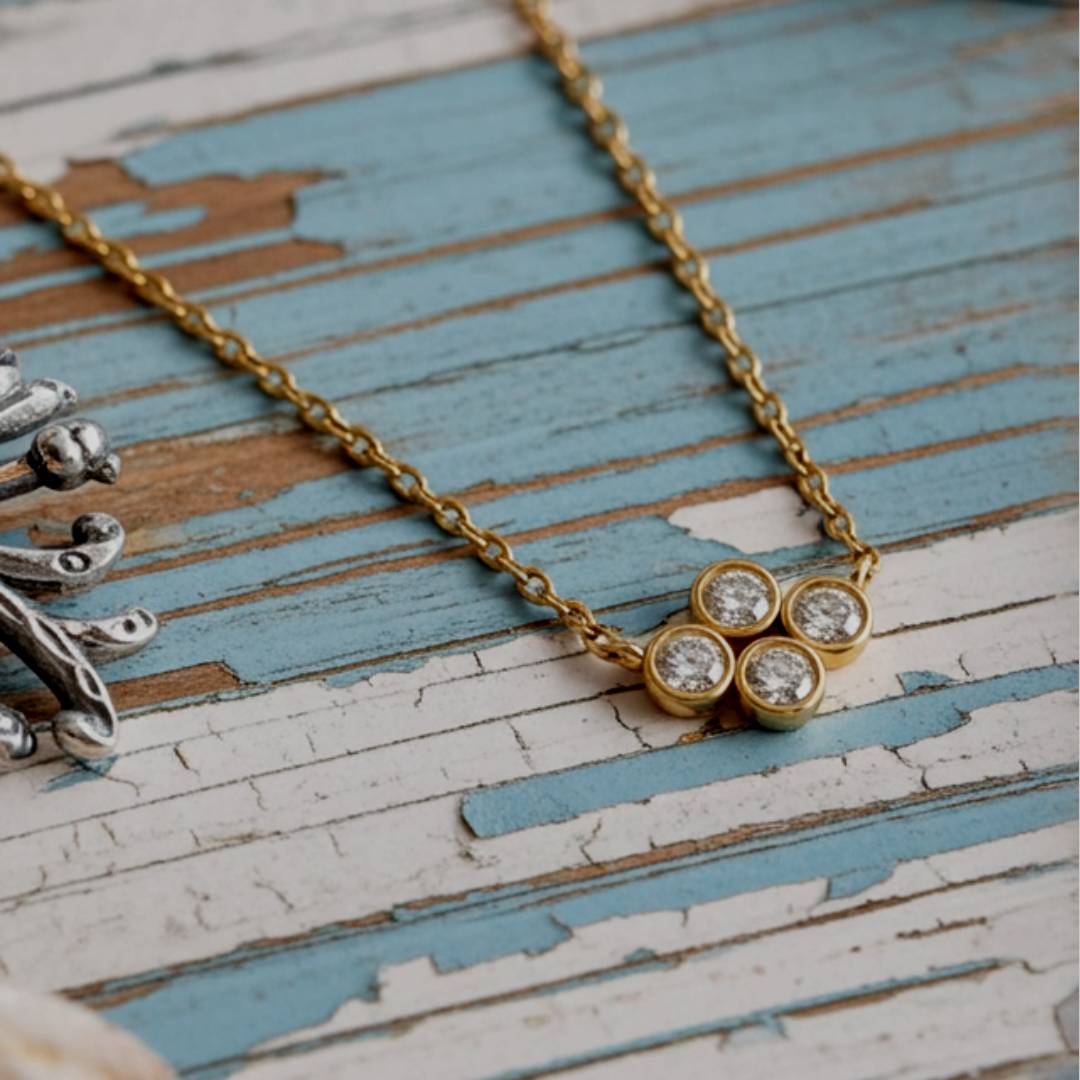 Gold necklace with a floral design on a rustic wooden surface