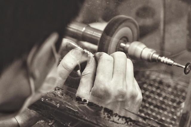 Person using a lathe to work on a piece of metal.