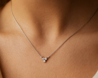 necklace with three small round pendants on a person's neck